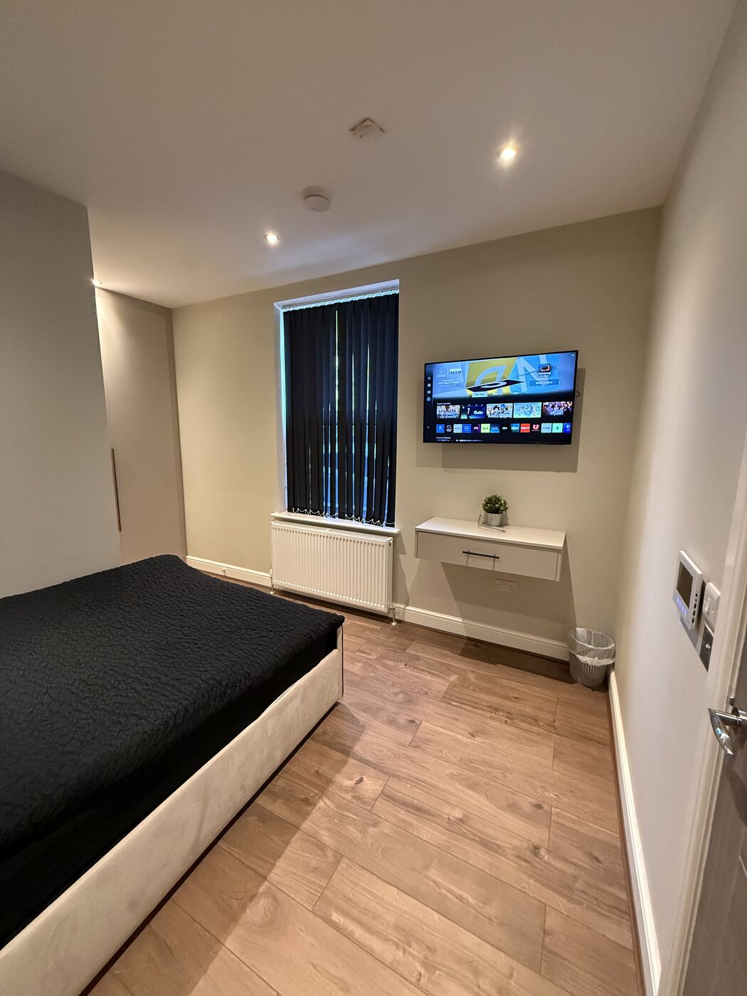 A bedroom with a wall-mounted TV